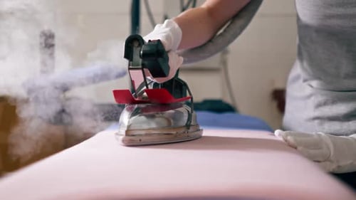 Close Up Professional Dry Cleaning Young Girl Ironing Pink with a Professional Iron with Steam