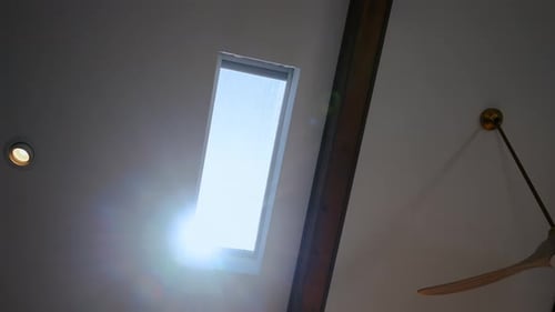 Janela de clarabóia de teto que permite que a luz natural entre no interior de uma casa moderna com vigas de madeira e