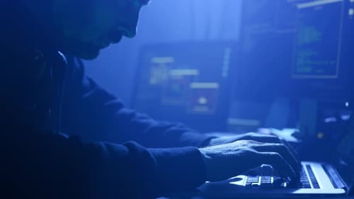 A Cybersecurity Professional is Deeply Analyzing Complex Data on a Laptop in a Dark Environment