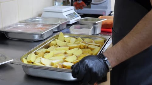 Chef Seasoning Cut Potatoes in Commercial Kitchen