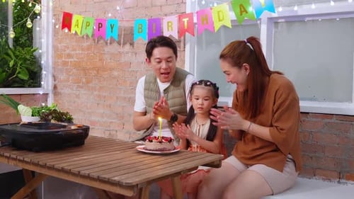 Family Celebrates Birthday with Cake and Clapping