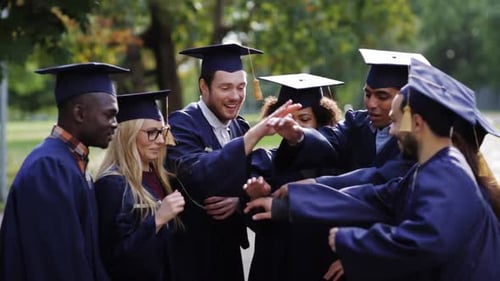 Diverse Graduates Stack Hands in Celebration