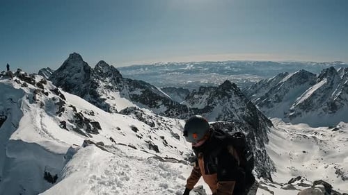 Climber Reaching the Snowy Summit of a Mountain and High Five with Friend; 4k Winter Mountains Lands