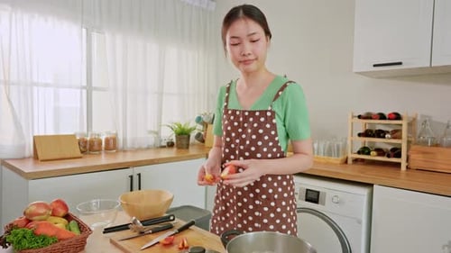 Asian young woman cooking healthy foods in kitchen in morning at home.