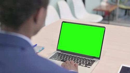 Young African Businessman Using Laptop with Green Screen