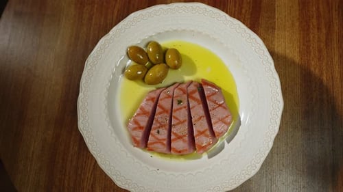Tuna Fish Cooked on Grill and Served with Bunch of Olives