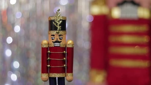 Toy soldier nutcracker on table, same but huge figurine in background.