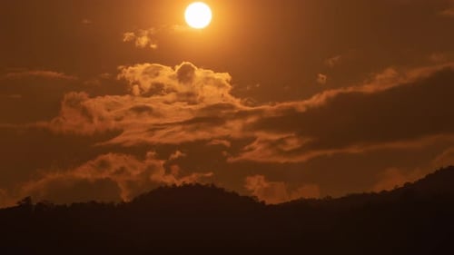 Sunset over a mountain in the orange sky 4k time lapse video.