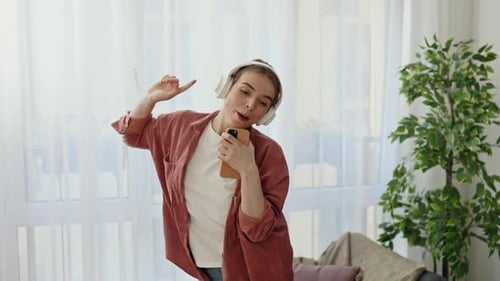 Young Woman Singing and Dancing with Headphones