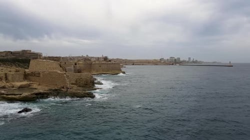 Panoramic view of the coastline close to Valletta. Ruins of Fort Ricasoli welcome visitors to malta'