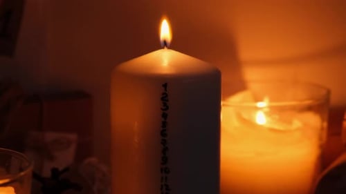 Burning Candle with Advent Numbers in the Night