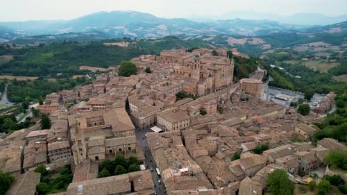 Sweeping aerial panorama of Urbino, Italy, featuring its historic hilltop town with charming brick b