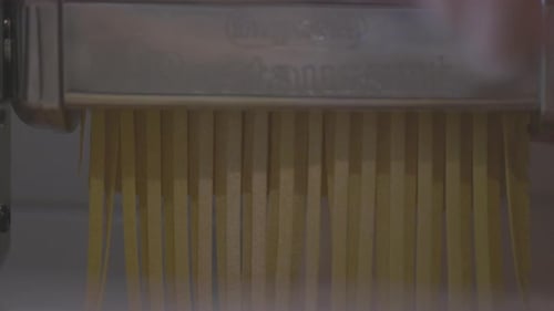 Italian Pasta Being Made on the Machine for Cutting Dough Fresh Handmade Pasta Coming Out From