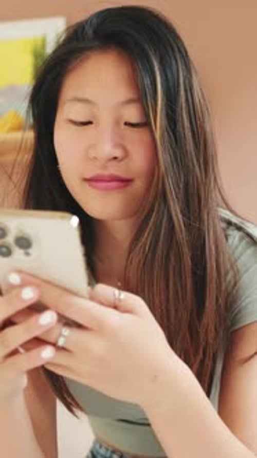 Young Adult Looking at Smartphone Indoors