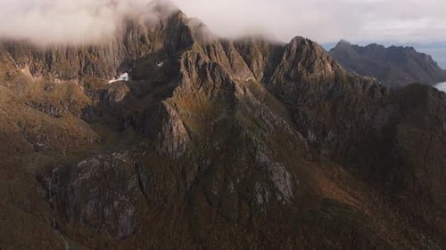 Dramatic Norwegian Heights Drone Footage Showcasing Jagged Mountains in the Midst of Clouds