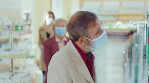 Slow Motion People Standing in Line in the Pharmacy In Medical Masks Inside Quarantine Safety