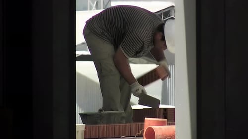 Construction Worker Building Brick Wall on Site