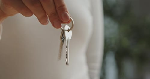Hand Holding Shiny Metal Keys on a Ring