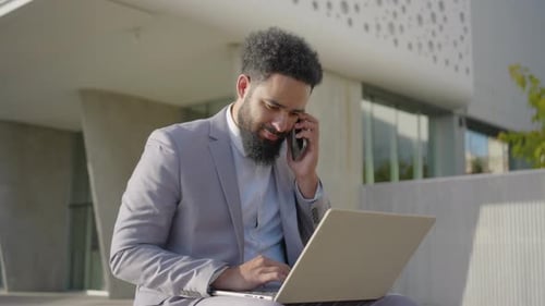 Adult Working on Laptop and Cell Phone Outdoors