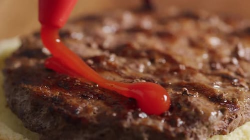 Closeup of Putting Ketchup on Hamburger. on Red Camera