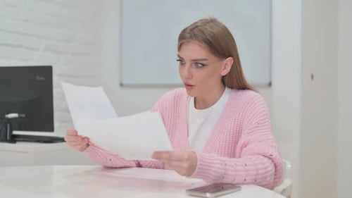 Excited Woman Celebrating Documents in Office