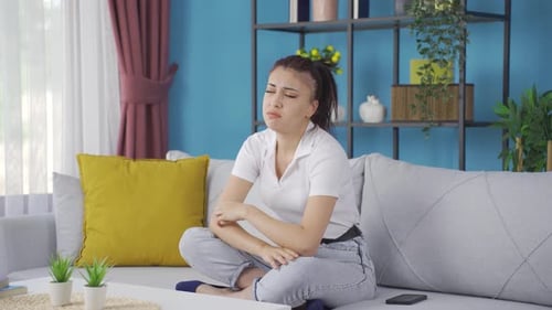 Thoughtful Woman Sitting on Couch Indoors
