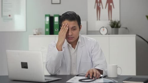 Stressed Doctor at Desk in Office