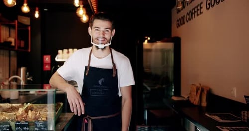 Content Young Guy Smiling During Work in Coffee Shop