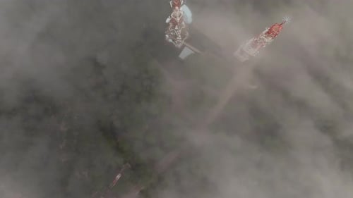 From High Altitude Perspective Communication Tower Emerges From the Morning Mist and Clouds Above a