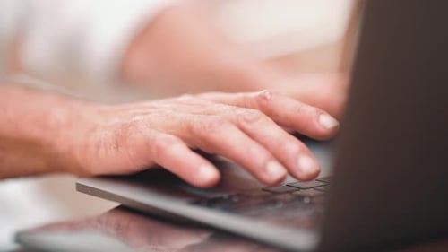 Close-up of the hands of mature businessman uses on laptop pc computer