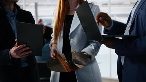 Tech Professionals Discussing Silicon Wafer with Tablet and Laptop