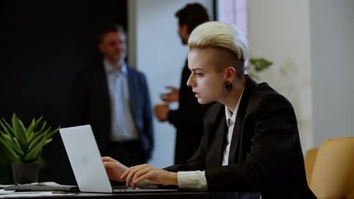 Focused Woman Working on Laptop in Modern Office