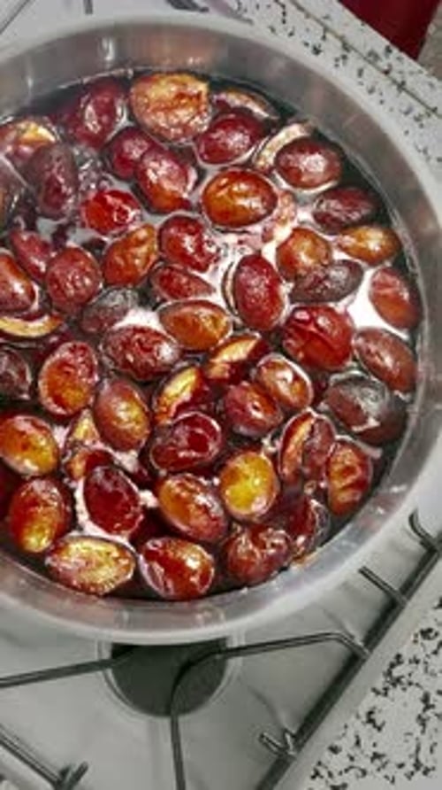 Deliciously scented Prunus domestica subsp jam is boiling in a tray.