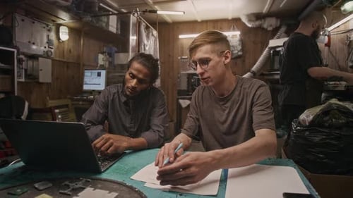 Young Adults Working in a Cluttered Tech Workshop