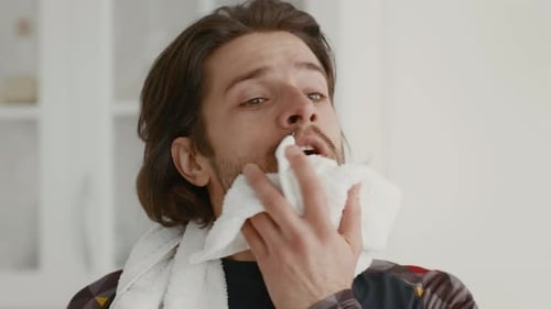 Man Wipes Face With Towel After Workout