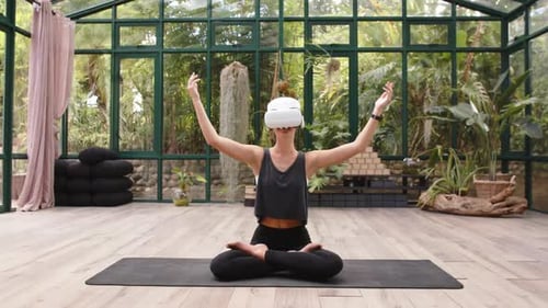 Woman Using VR Headset for Yoga in Greenhouse