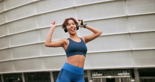 Happy woman, dancing and headphones outdoor for fitness, motivation or positive mood with streaming