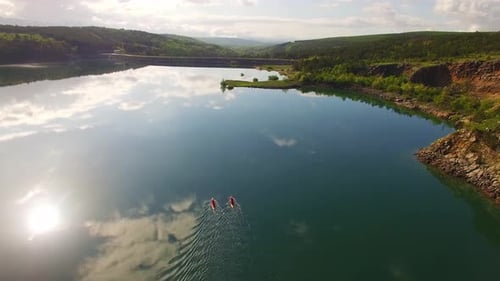 People kayaking in river, green nature and sky full of clouds.