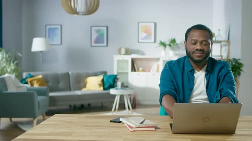 Man Working on Laptop at Home at Desk