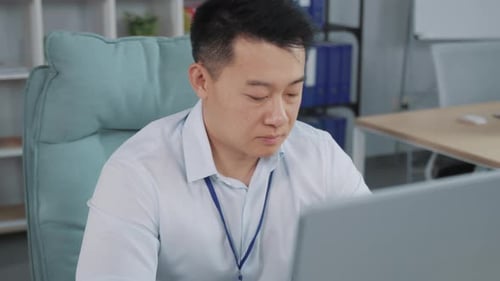 Portrait of Serious Businessman Looking at Computer Screen in Office Asian Male Manager Typing on