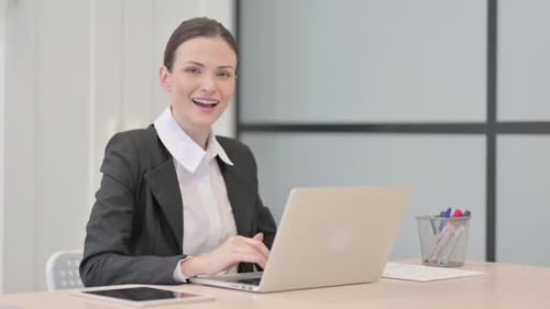 Businesswoman Typing on Laptop in Modern Office