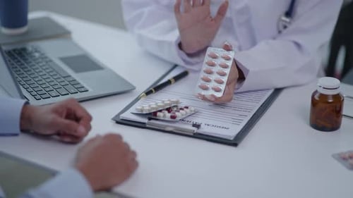 Close up of doctor's hands is explaining and advising about using pills medicine to patient.