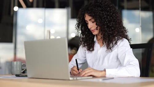 Focused Young Businesswoman Working on Laptop in Modern Office