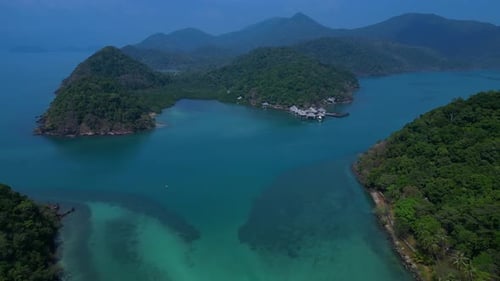 Island with pier leading to tropical beach. Stunning aerial view flight drone