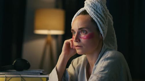 Woman wearing eye patches and a towel on her head