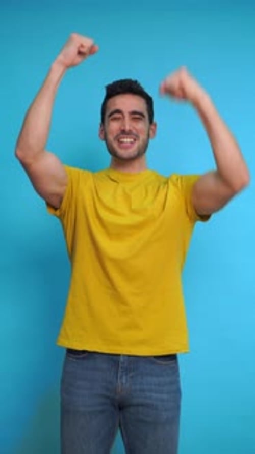 Excited Man with Raised Arms in Studio