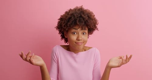 Verwirrte zögernde junge Afroamerikanerin sieht mit verwirrtem, verwirrtem Gesichtsausdruck aus