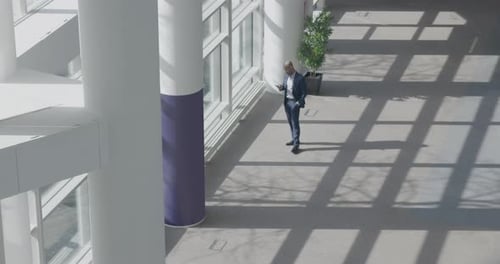 Real estate agent Standing in Office Lobby and using Smart phone, waiting for Client