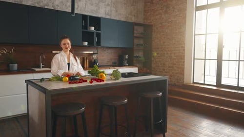 Woman Prepares Vegetables at Kitchen Island