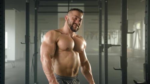 Medium Shot of Smiling Bodybuilder with Bare Fit Torso Crossing Arms on Chest